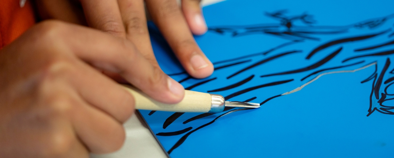 Students during a mentoring session with a practising artist, preparing their lino-print artwork for the book, photograph by Hugh Sando