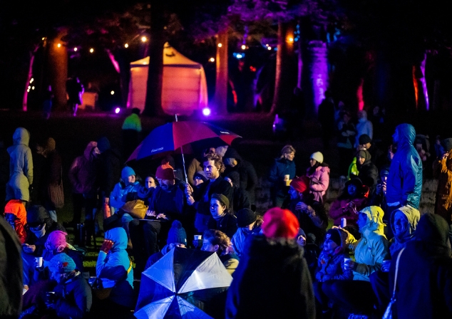 Crowd huddled under umbrellas and colourful lights at Melville Midwinter. 