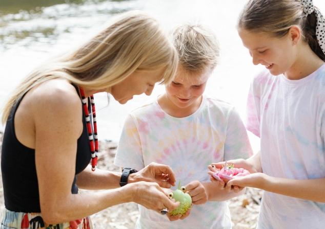 Image of a women with to children showing and sharing toys